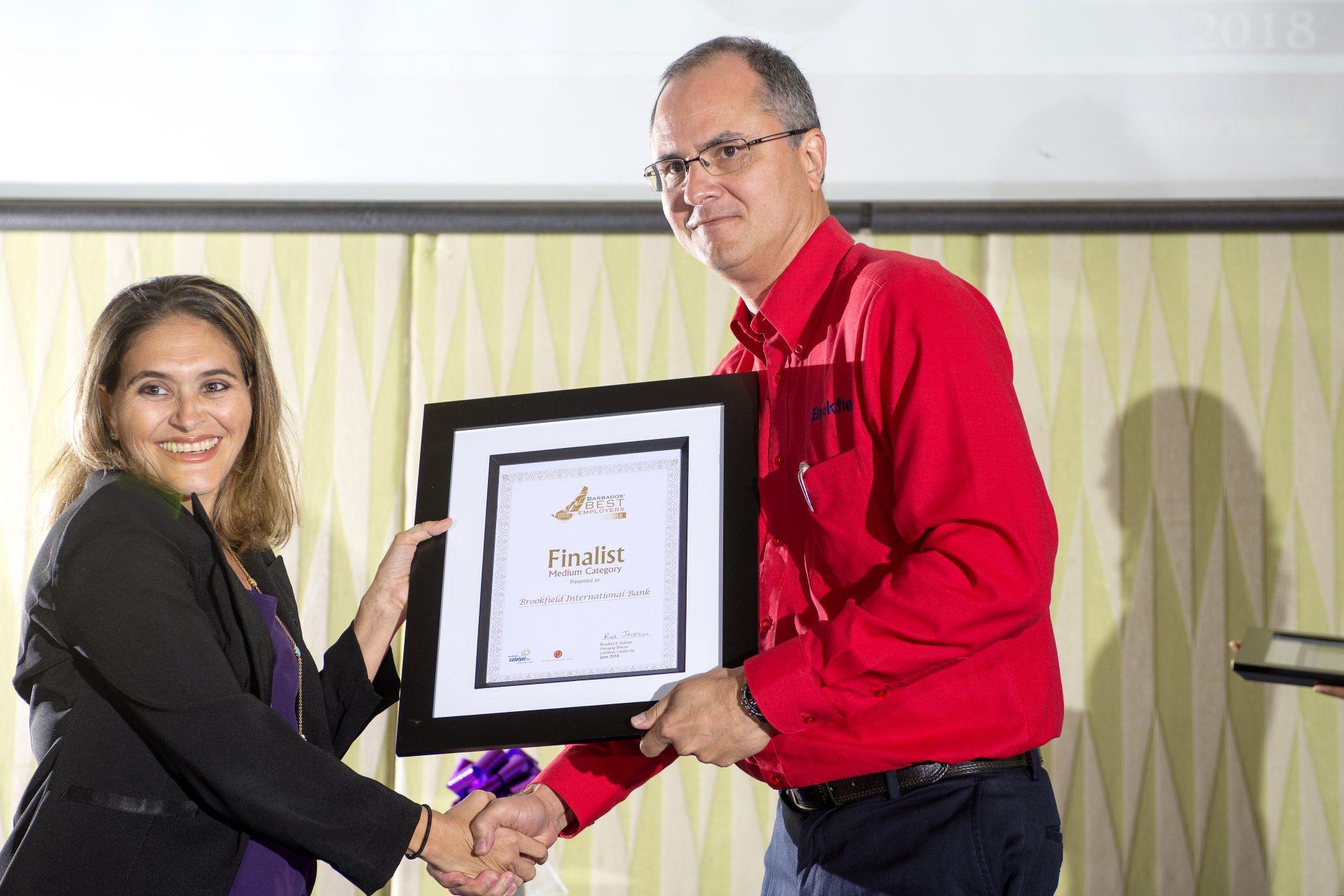 Jacqueline presenting Gregory McConnie at Brookfield Int'l Bank with a Certificate as one of the Finalist in the medium category